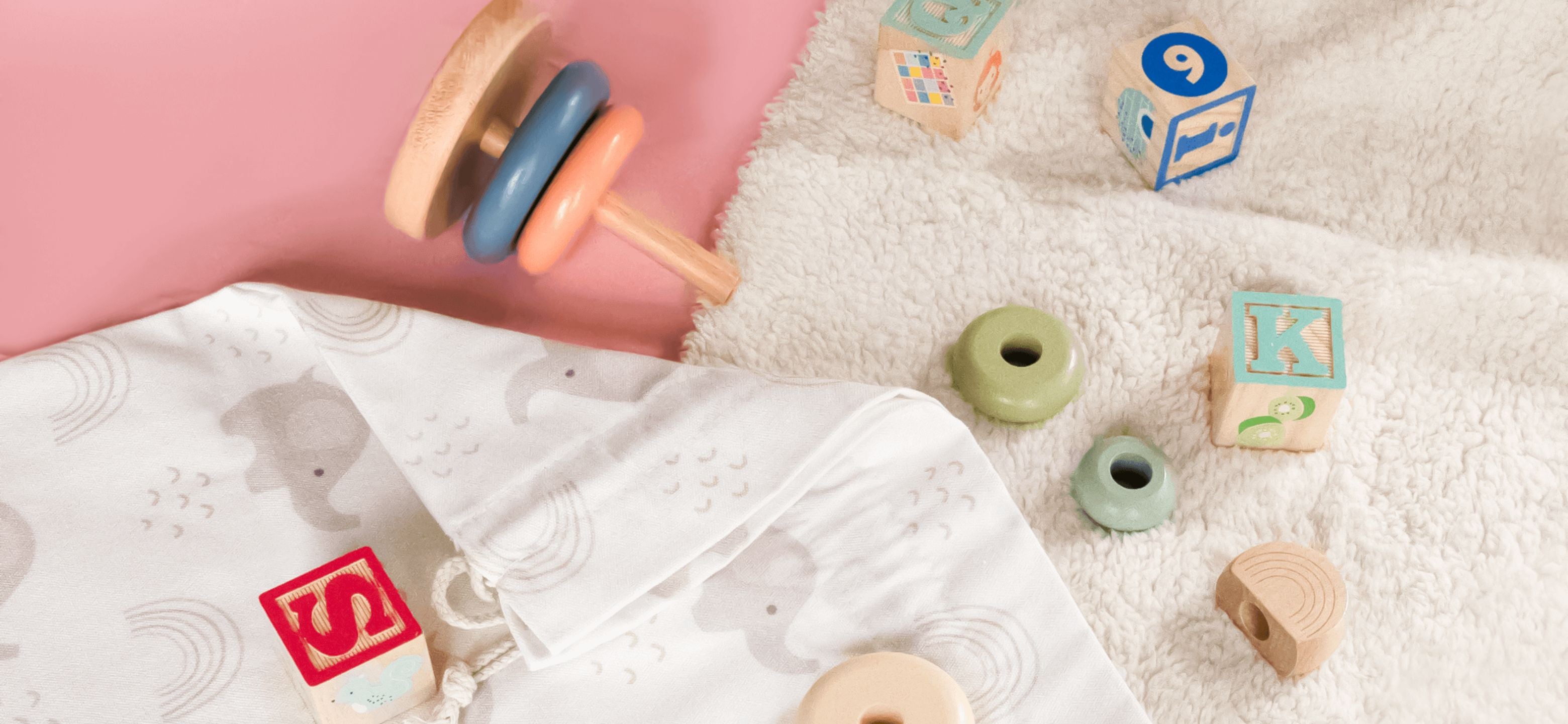 Baby toys laying on fabric gift bag