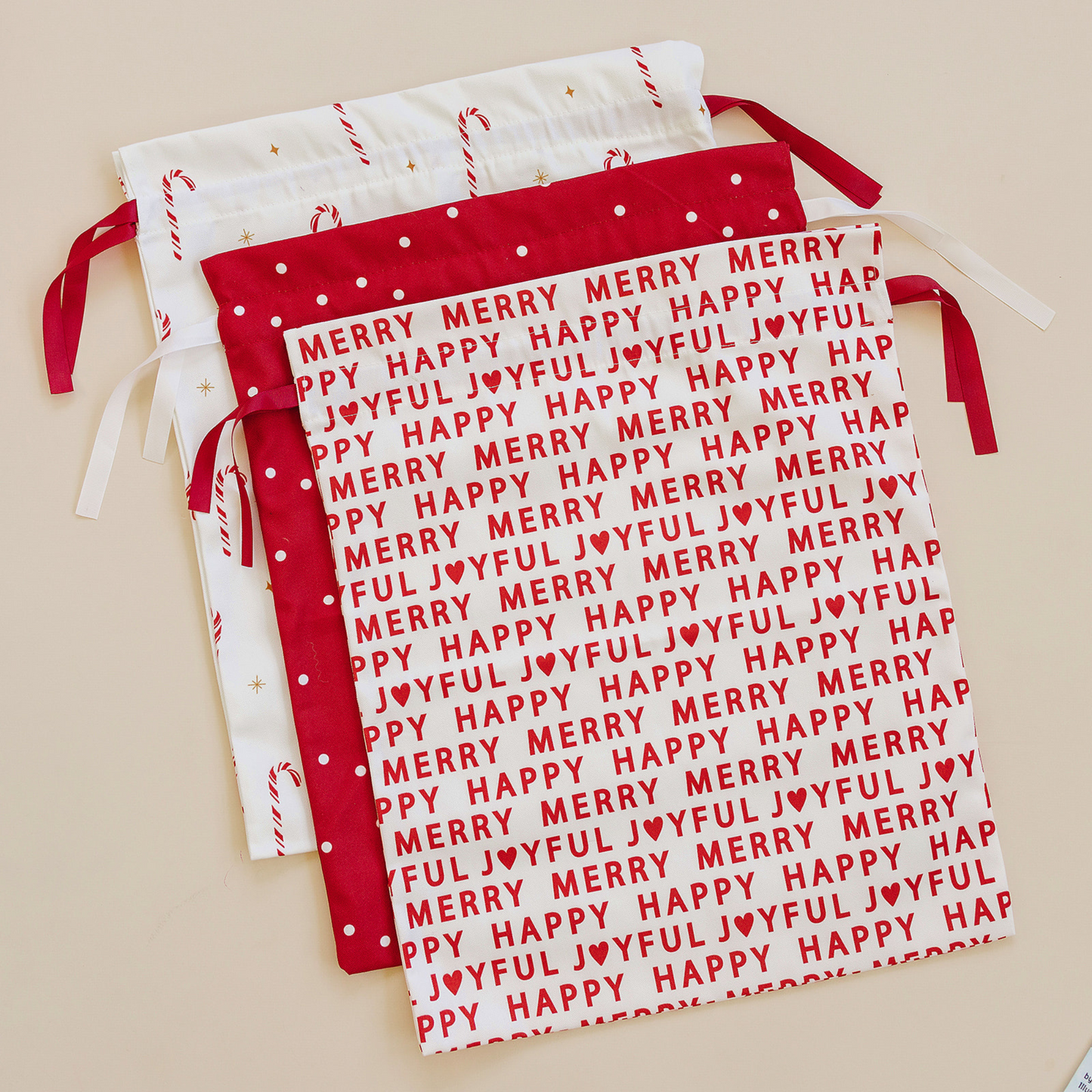 Red and white fabric with 'Merry Happy Joyful' text on a beige background