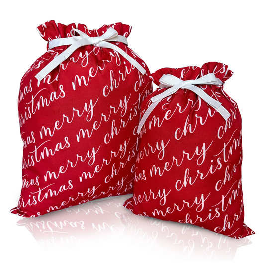 Two vibrant red fabric gift bags with 'Merry Christmas' text in white, tied with white ribbons.