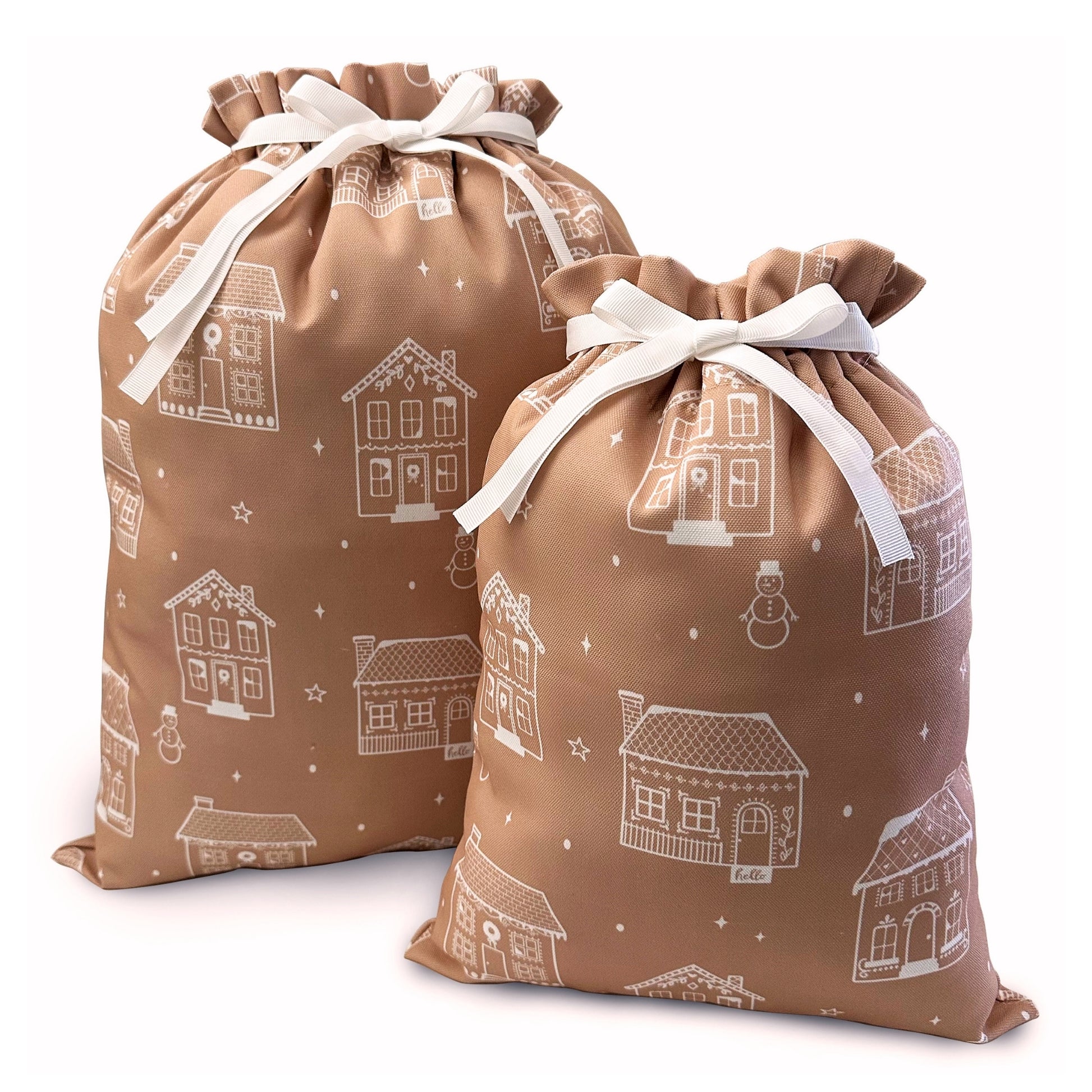 Two gingerbread drawstring gift bags with white ribbon bows, printed with a white winter house pattern.